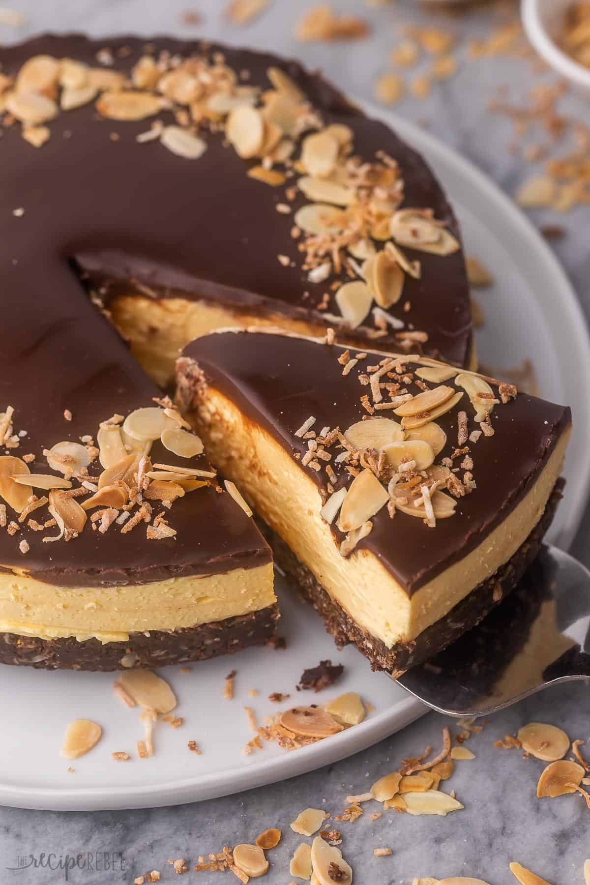 a piece of no bake nanaimo bar cheesecake being lifted off plate.