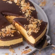 close up of a piece of no bake nanaimo bar cheesecake being lifted off plate.