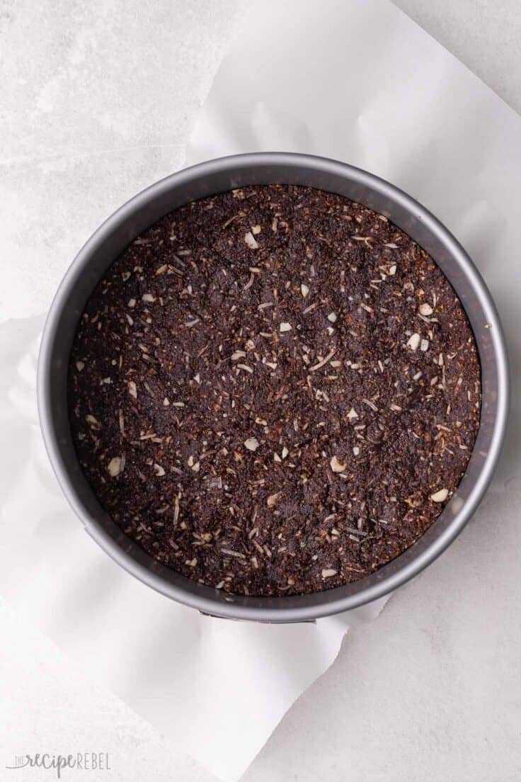 grey spring form pan with crust pressed in bottom.