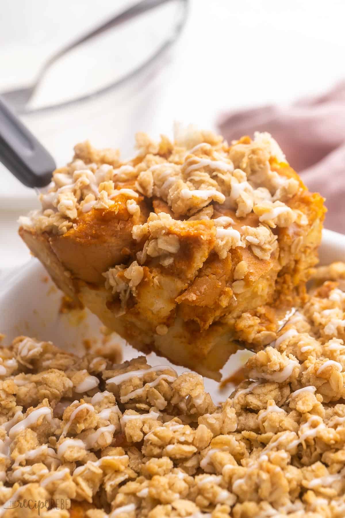 a piece of pumpkin french toast casserole being scooped out of pan.