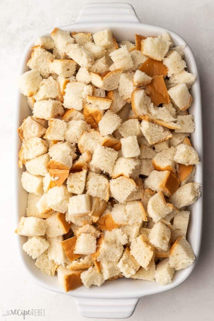 white baking dish filled with cubed french bread.