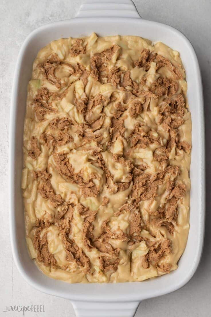 white pan full of apple fritter cake ready to be baked.