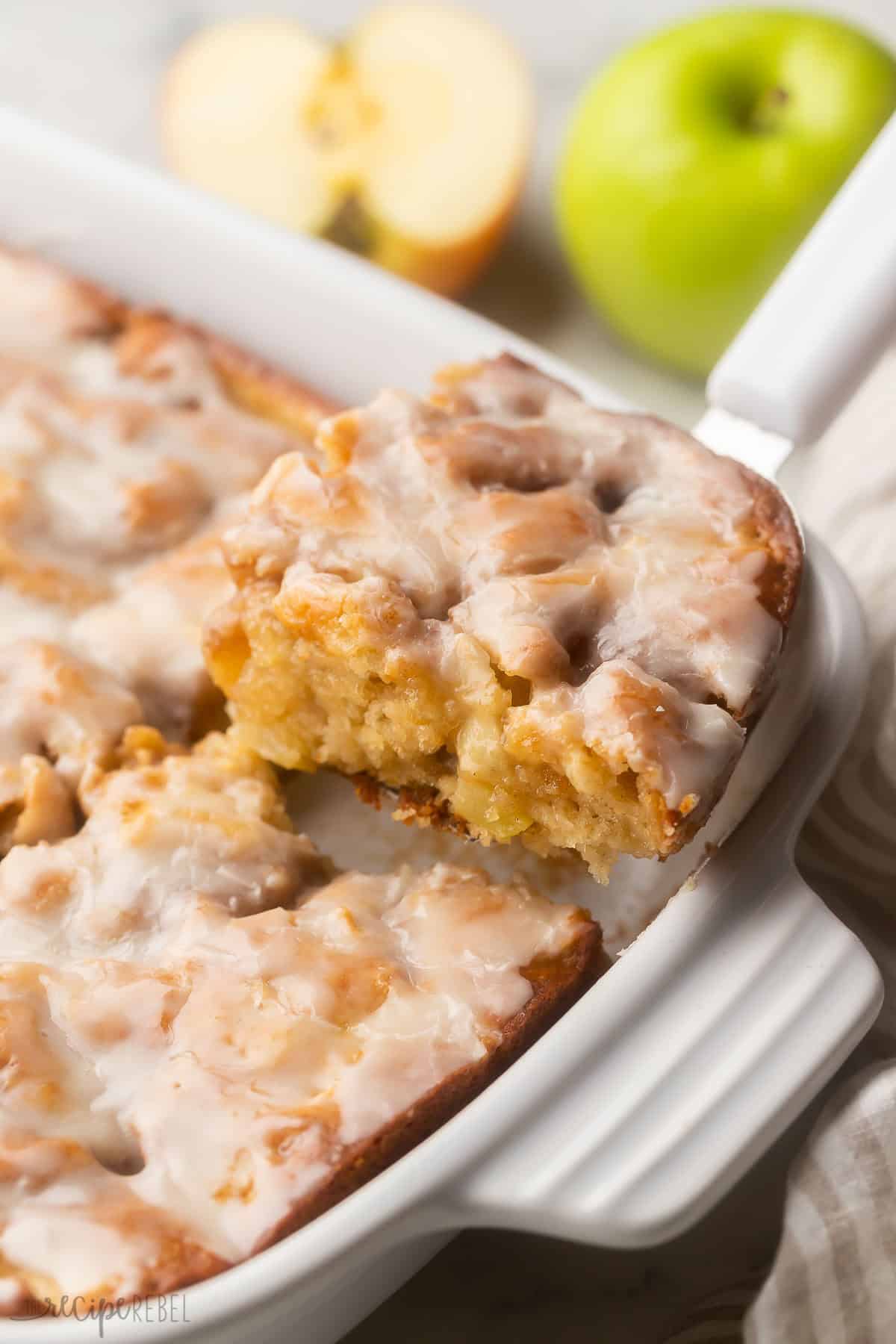 a piece of apple fritter cake being scooped out of pan.