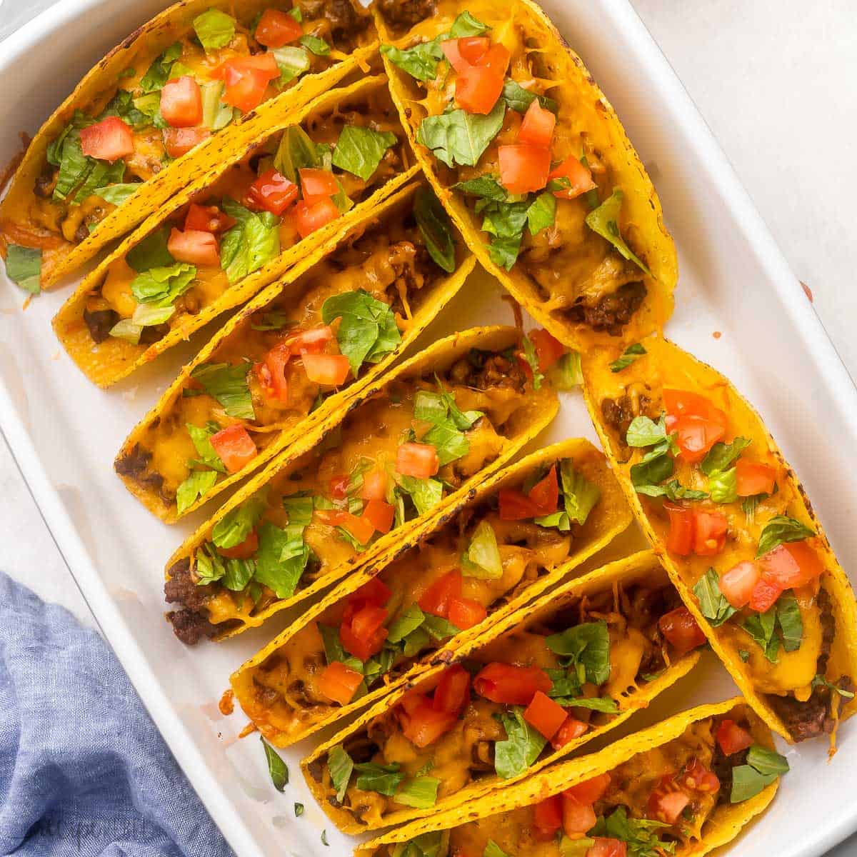 baked bbq cheeseburger tacos in a white dish.