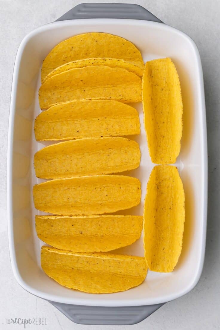 large white baking dish filled with taco shells.