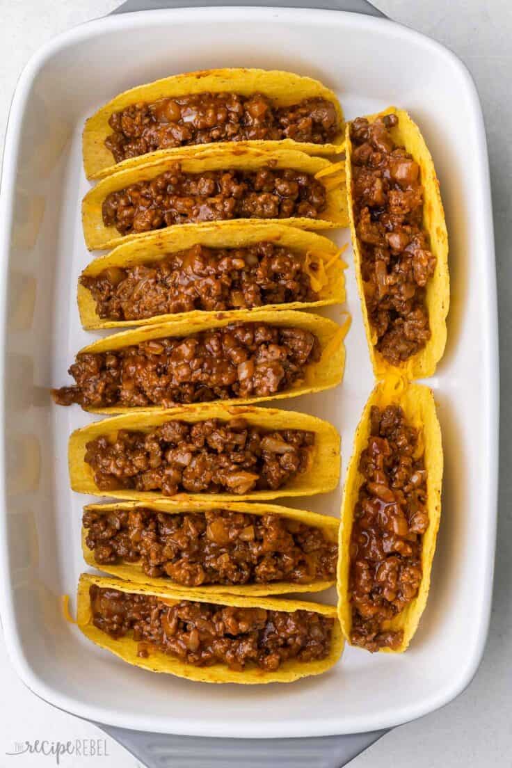 filled tacos inside a white baking dish.