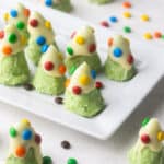 close up of christmas tree cookies on a white platter.
