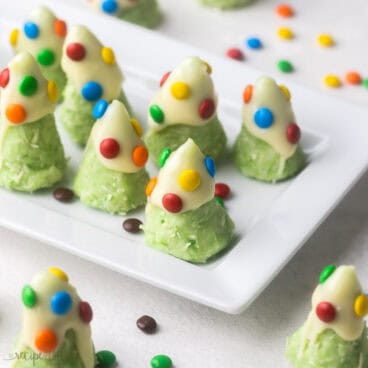 close up of christmas tree cookies on a white platter.