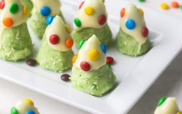close up of christmas tree cookies on a white platter.