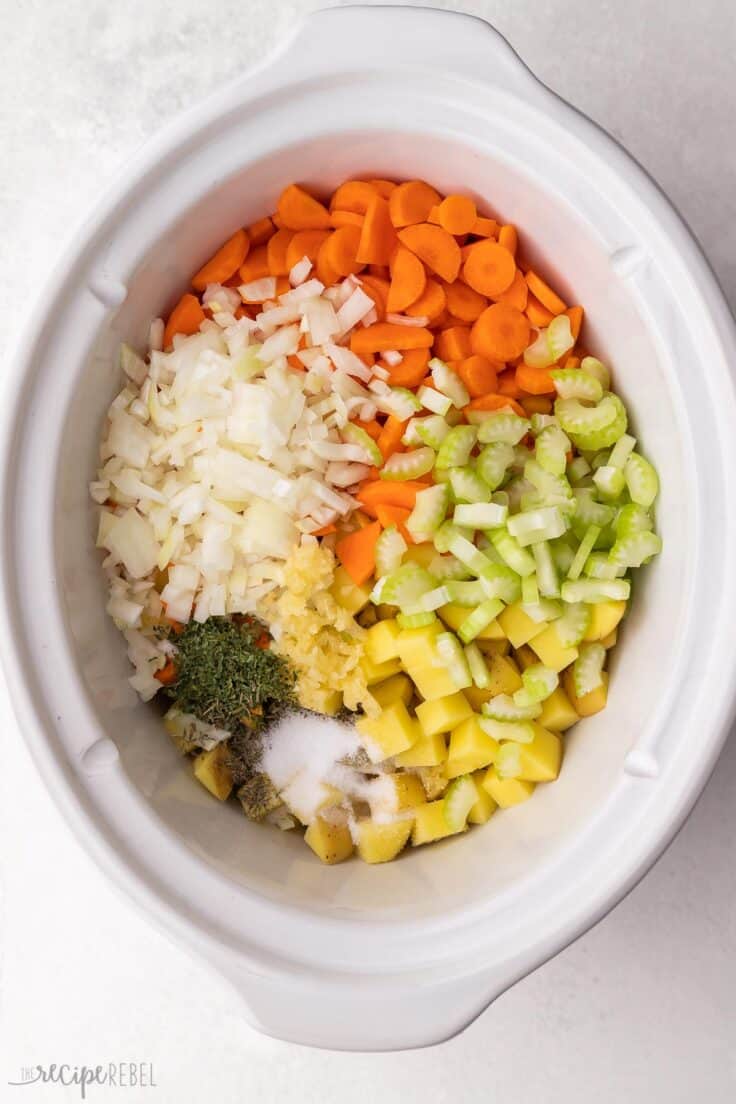 chopped vegetables and spices in white crockpot.