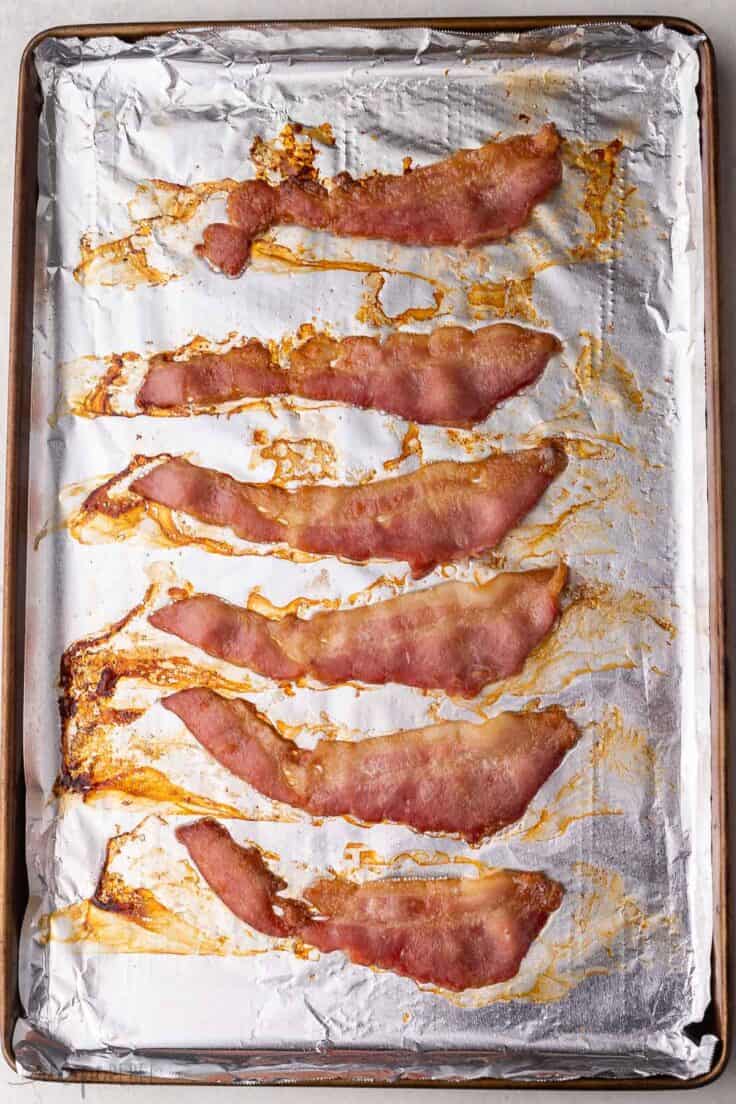 six slices of cooked bacon in a sheet pan.