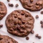 close up of a double chocolate chip cookie with chocolate chips around it.