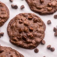 close up of a double chocolate chip cookie with chocolate chips around it.