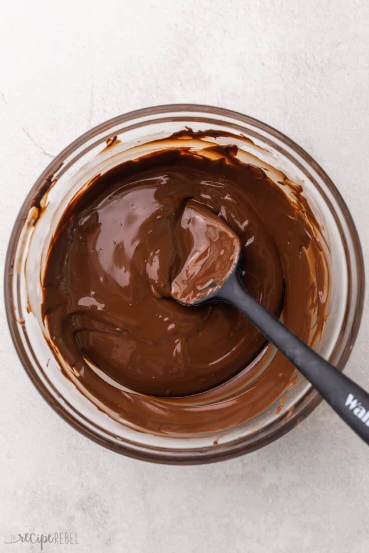 glass bowl with spatula and melted chocolate.