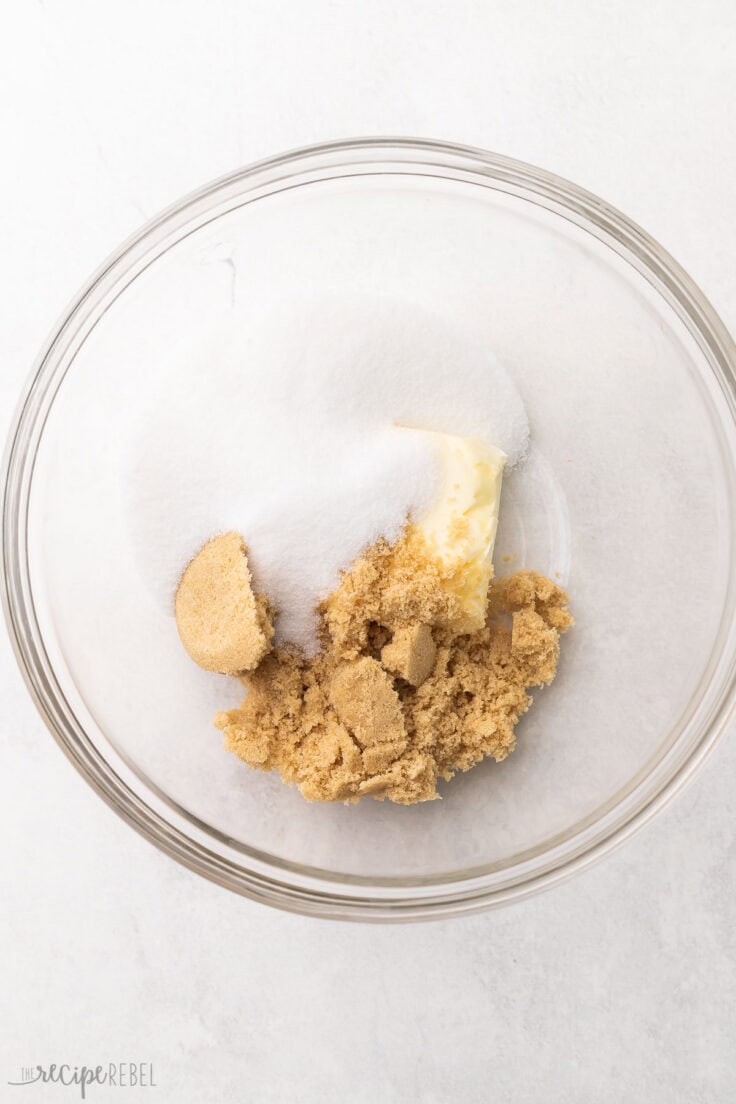unmixed sugar and butter in a glass mixing bowl.