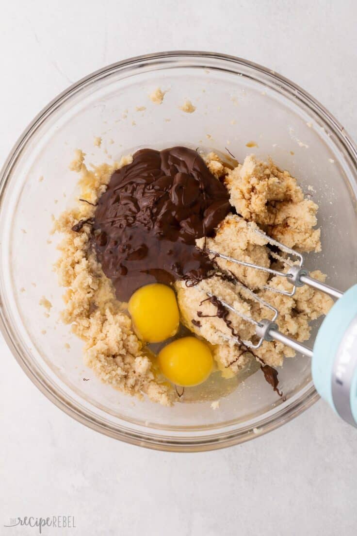 chocolate and eggs added to bowl of cookie dough mixture.