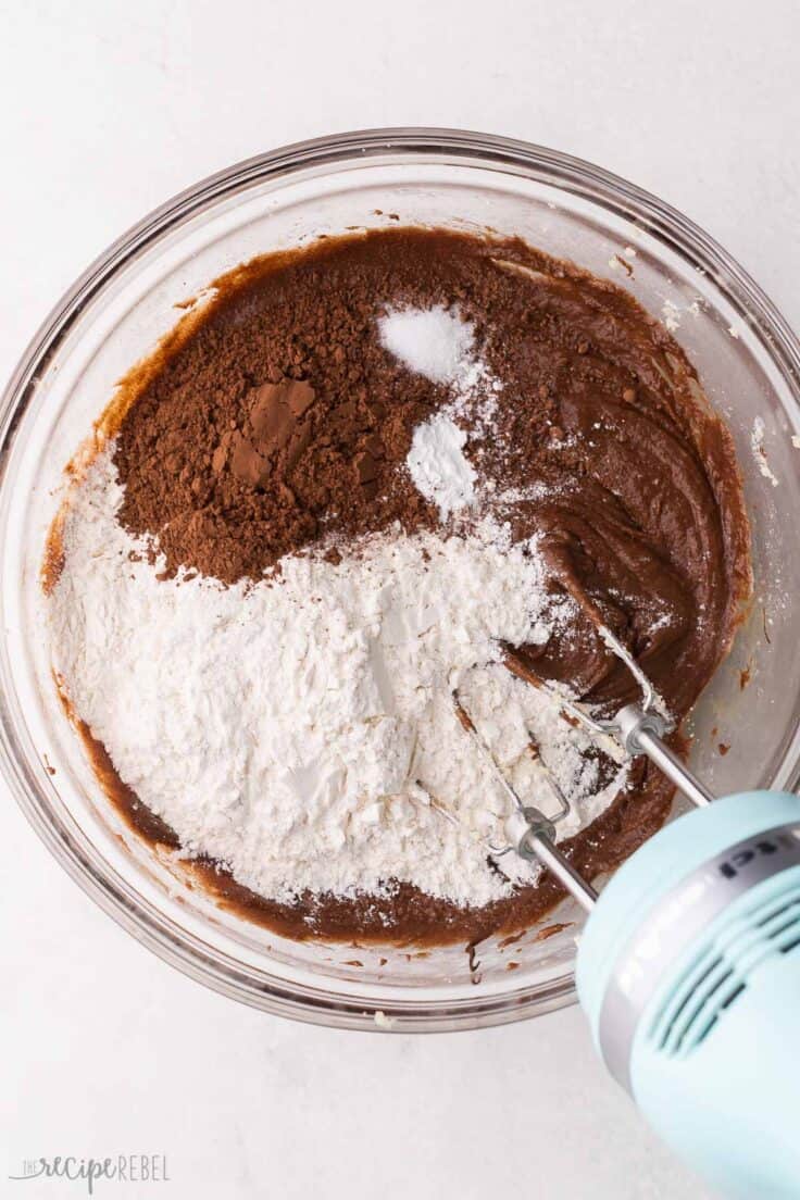 flour added to cookie dough ingredients in glass bowl.