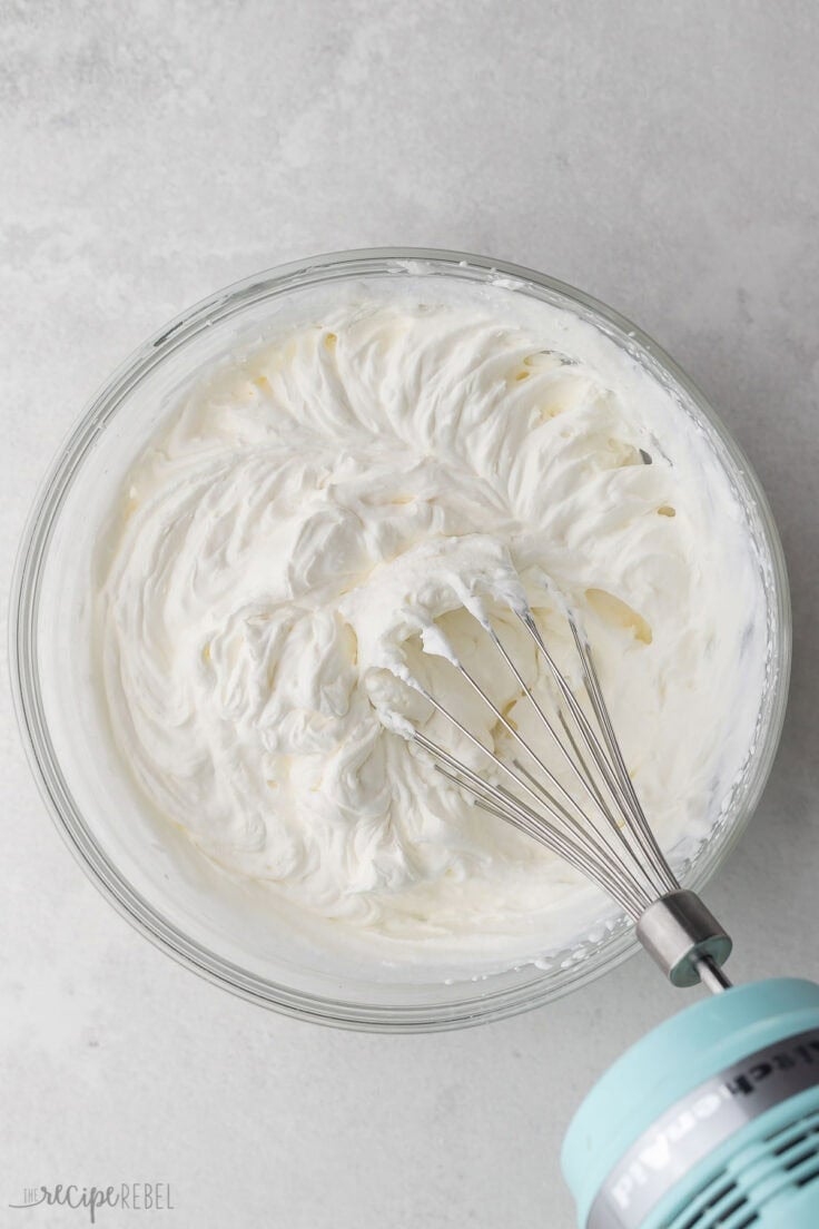 whipped cream in glass bowl and mixer off to the side.