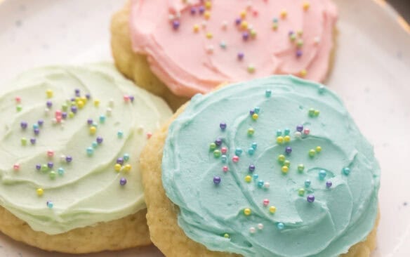 three cookies stacked on a speckled plate.