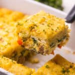 a piece of tater tot casserole being lifted out of pan.