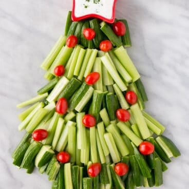 picture of cut up vegetables in the shape of a Christmas tree with a small star shaped bowl of ranch dressing as the star