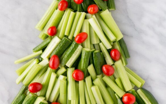 picture of cut up vegetables in the shape of a Christmas tree with a small star shaped bowl of ranch dressing as the star