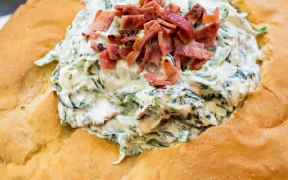 piece of bread with hole cut in the middle and filled with bacon spinach dip