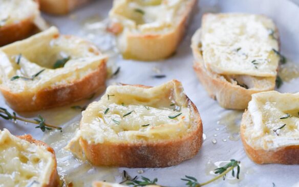 toasted baguette slices topped with melted brie cheese, honey, and herbs