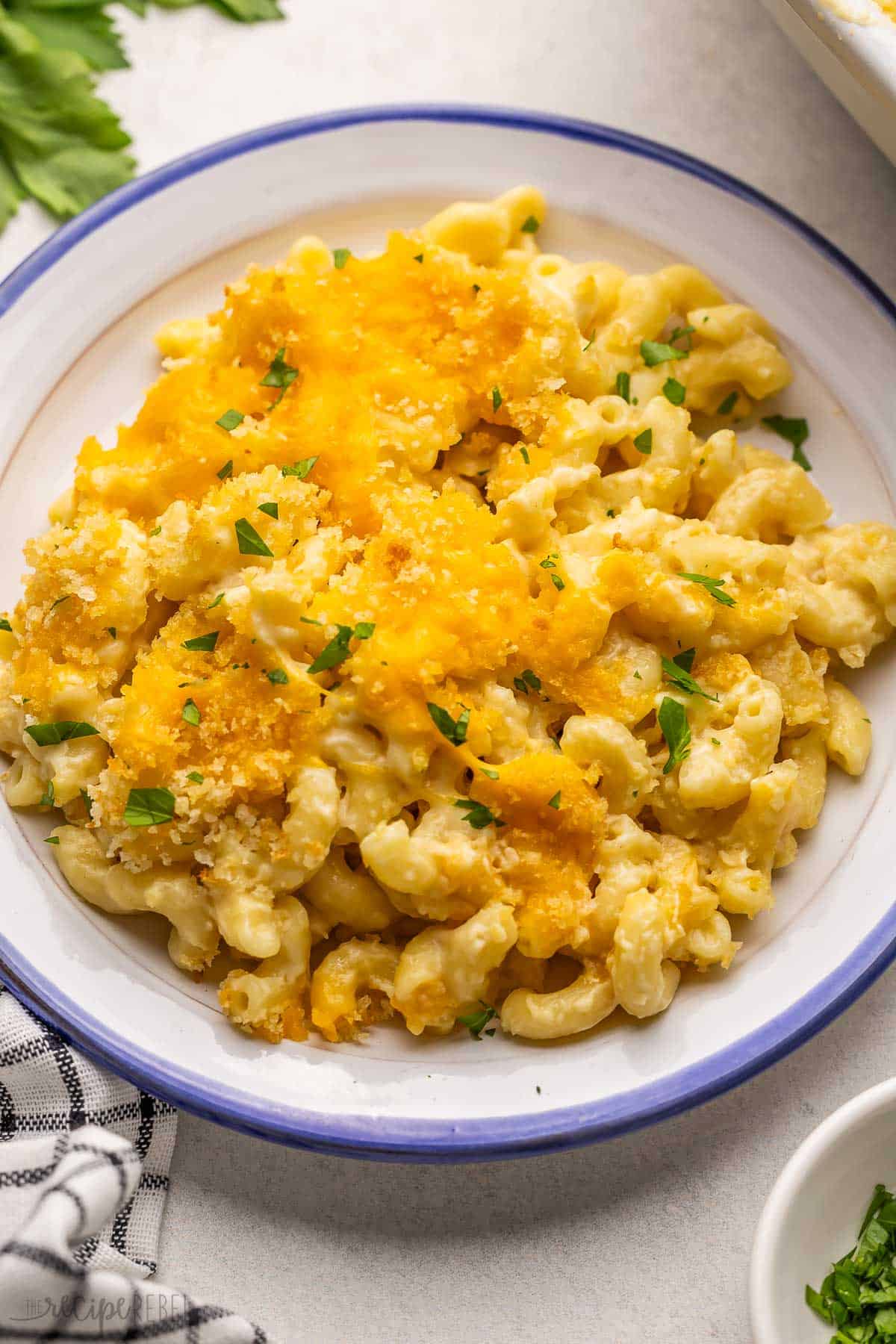 a blue and white plate full of baked mac and cheese.