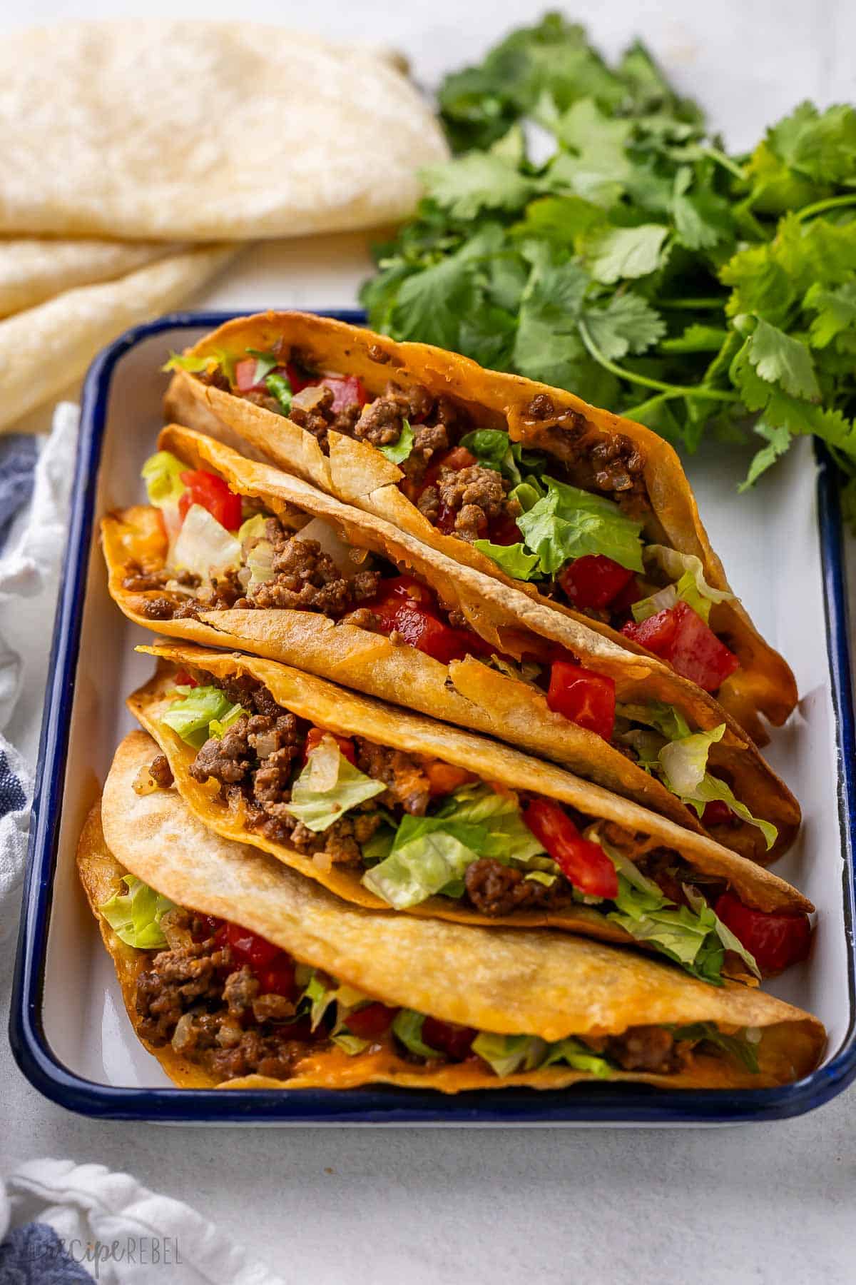 crispy baked tacos with parsley behind it.