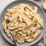 blue plate with fork and garlic parmesan chicken pasta.
