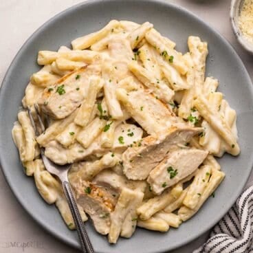 blue plate with fork and garlic parmesan chicken pasta.