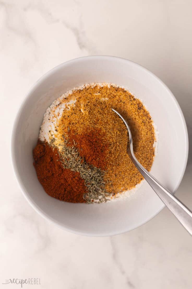 white bowl with unmixed spices and spoon.