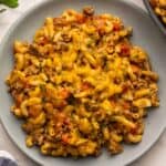 a plate filled with taco macaroni topped with chopped parsley.