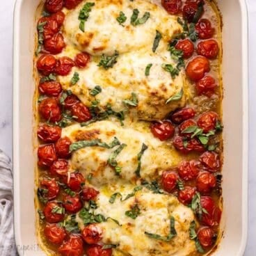 baked caprese chicken topped with chopped basil.