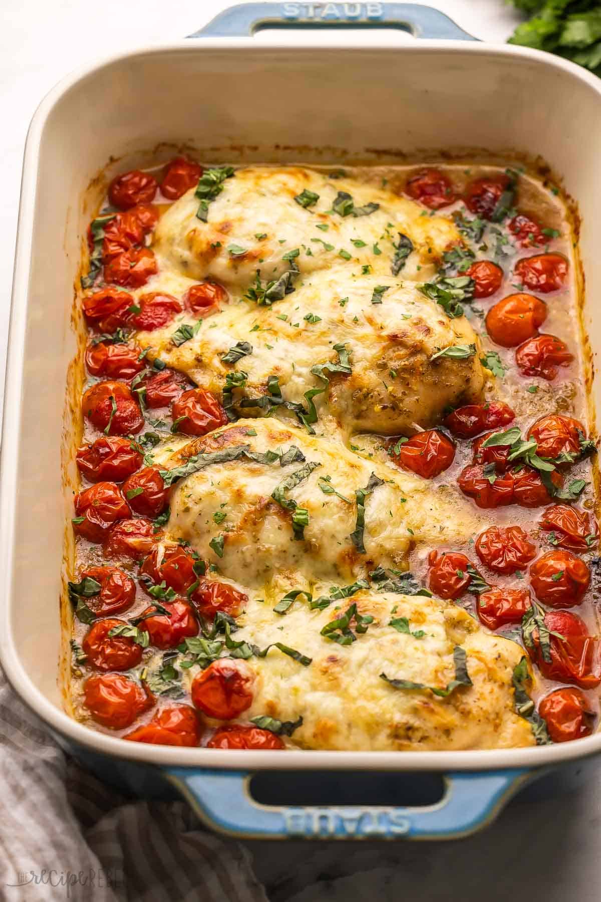 large pan of caprese chicken topped with chopped basil.