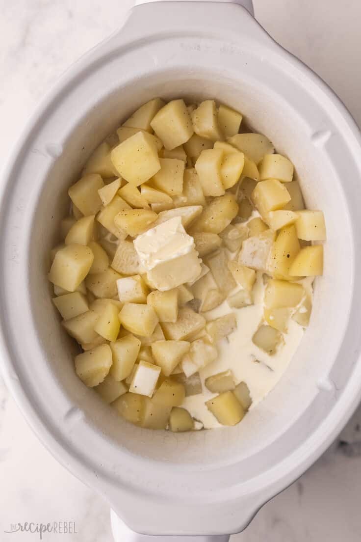 butter and cream added to potatoes in slow cooker.