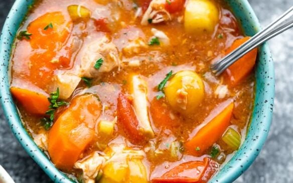 bowl of tuscan slow cooker chicken soup with a spoon