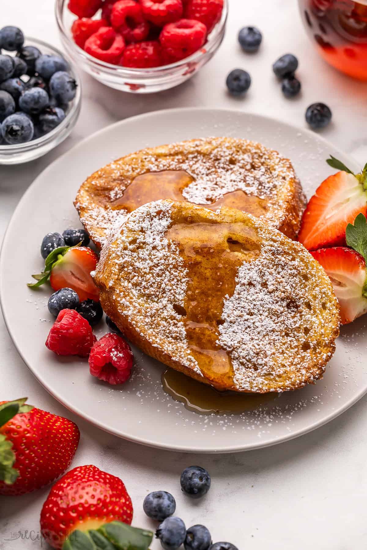 a plate of air fryer french toast topped with powdered sugar and syrup.