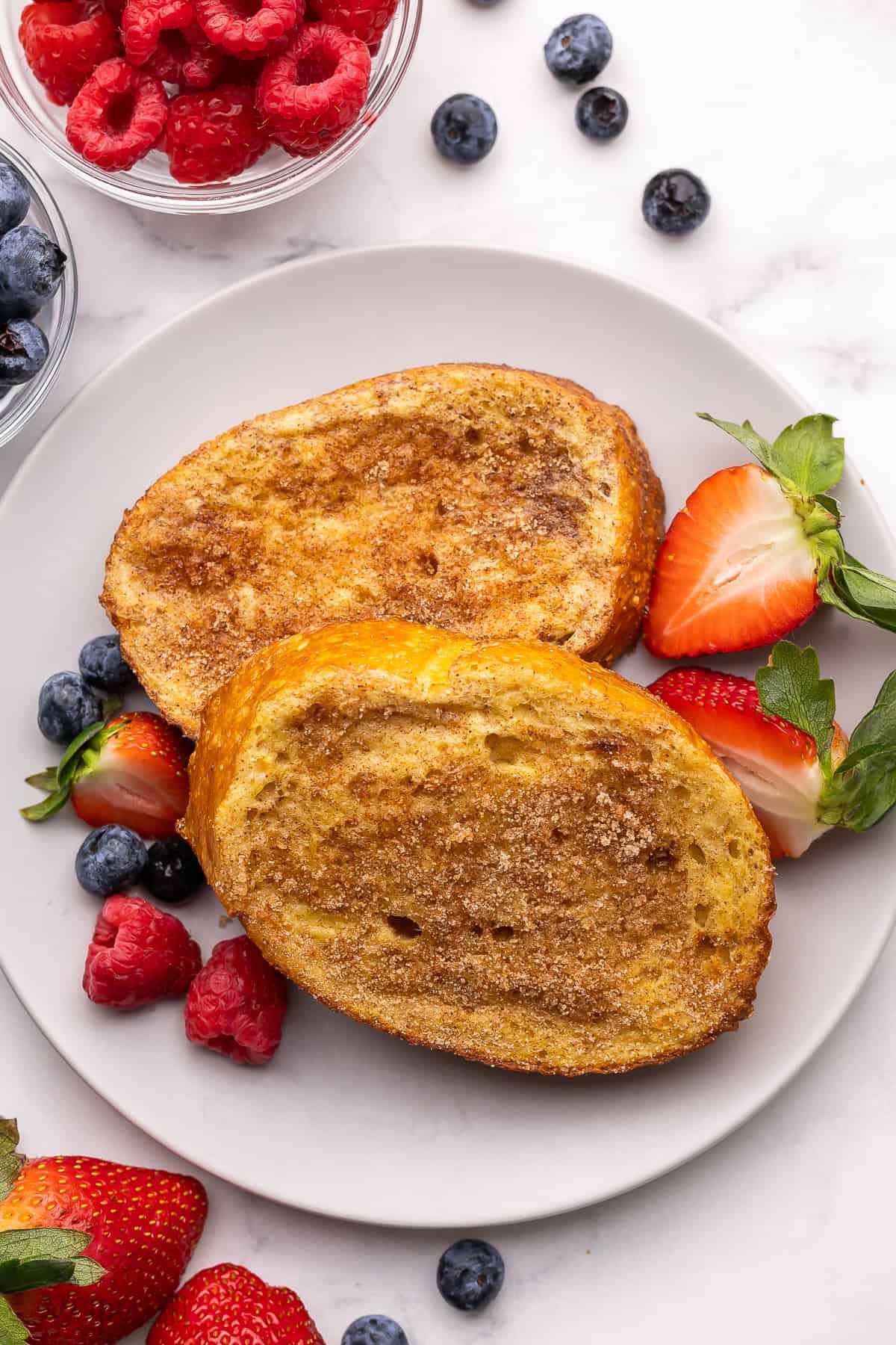 a plate of air fryer french toast with berries beside it.