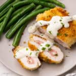 square image of chicken cordon bleu with cream sauce.