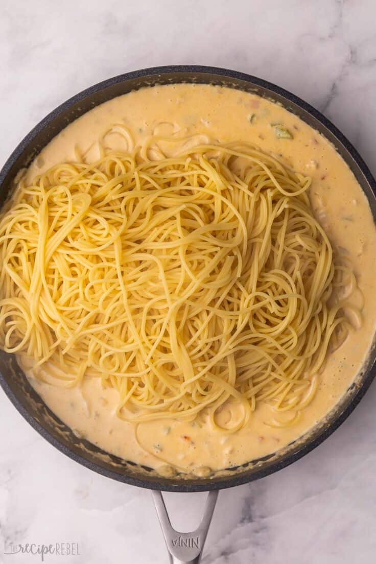 cooked spaghetti noodles added to pan with sauce.