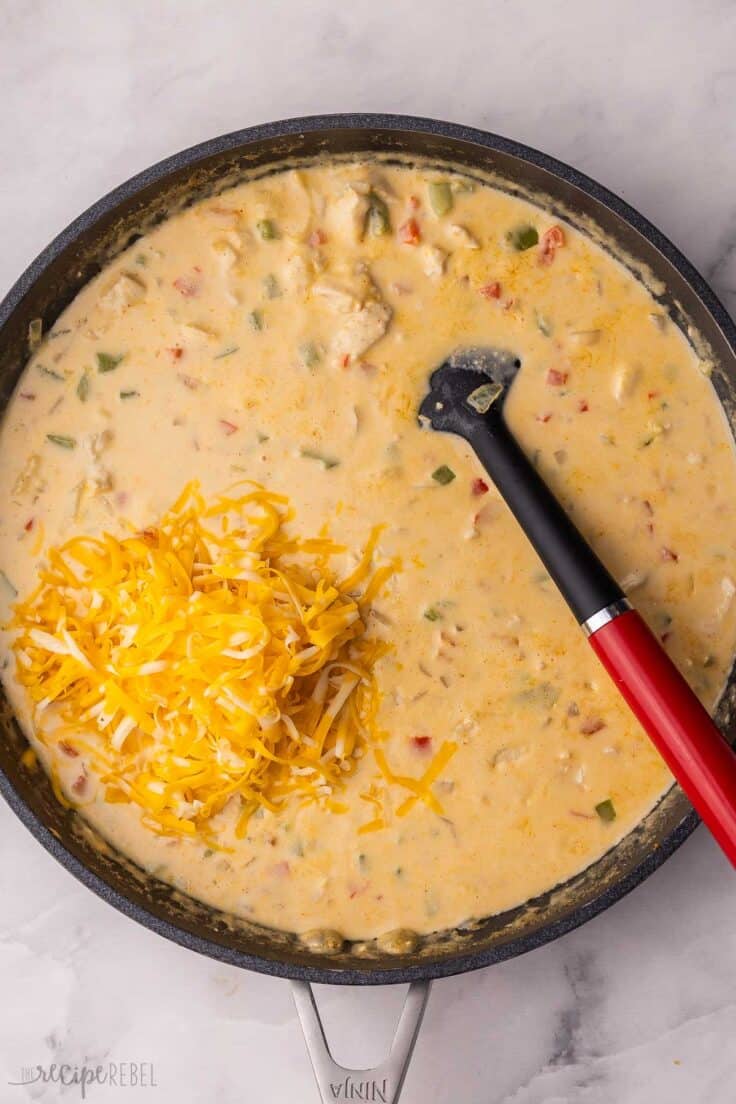 shredded cheese added to pan of chicken spaghetti.