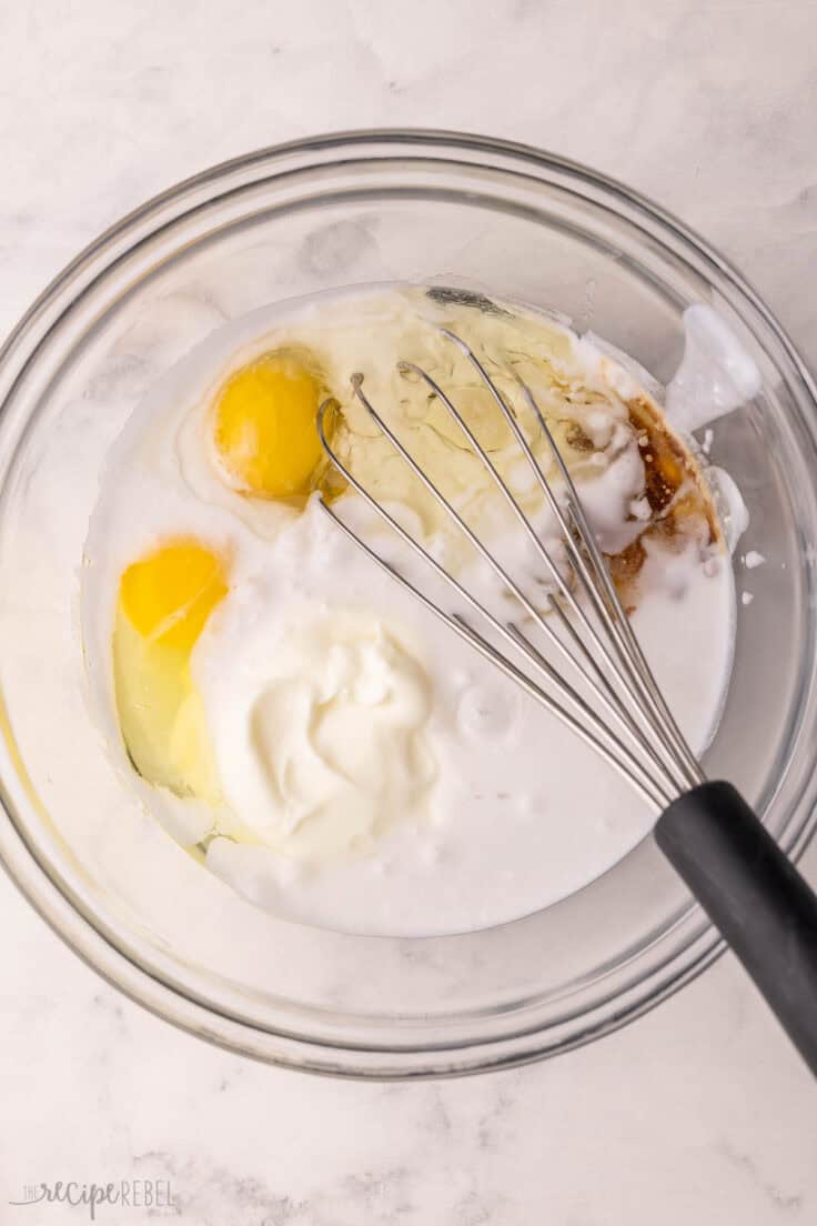 unmixed wet ingredients in glass mixing bowl with whisk.