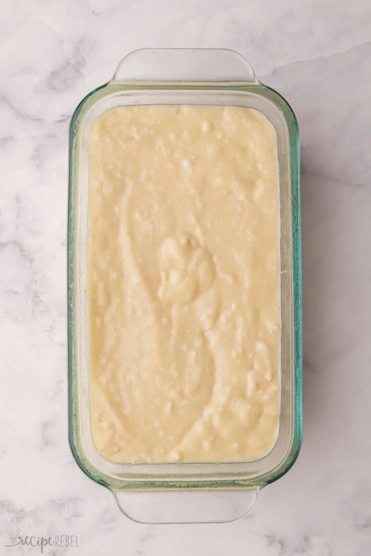 glass loaf dish filled with coconut bread batter.