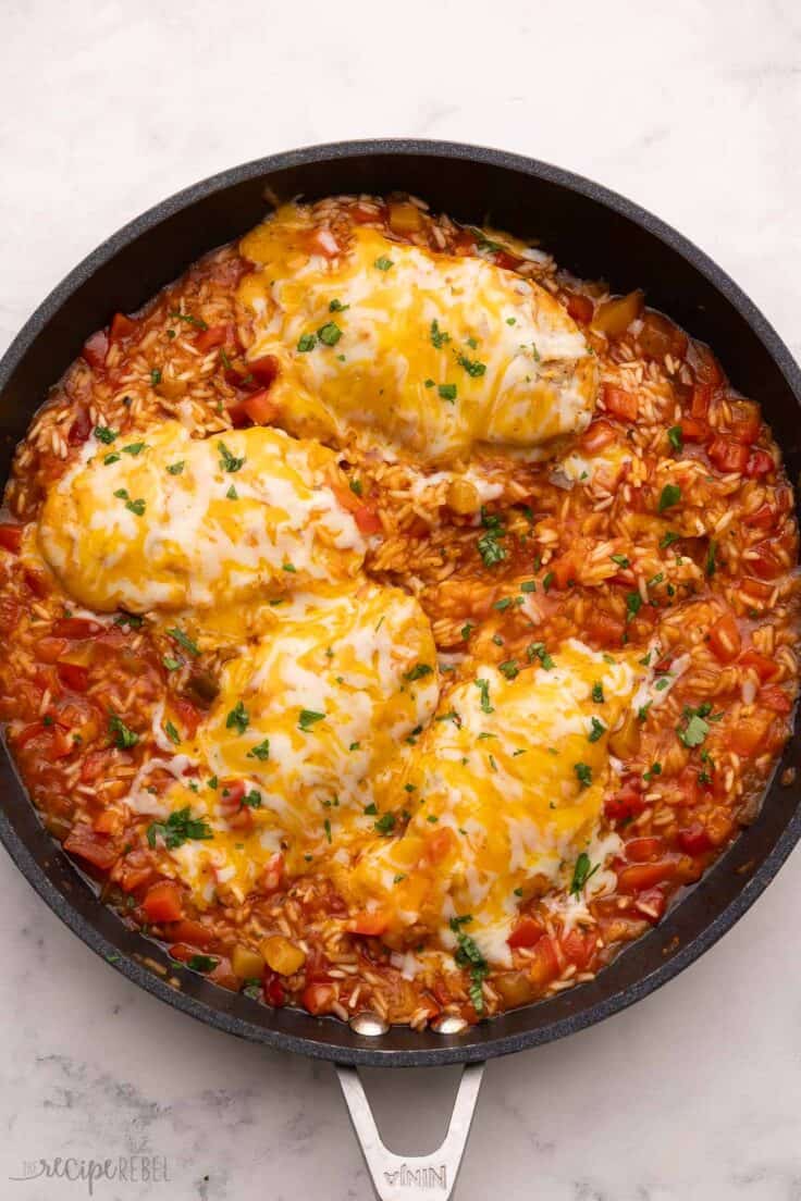 large black pan filled with mango salsa chicken and rice.