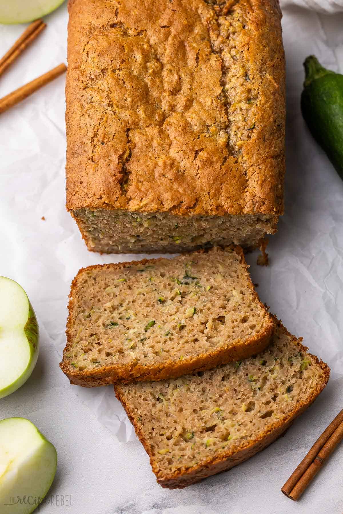 two slices of zucchini apple bread beside the loaf.