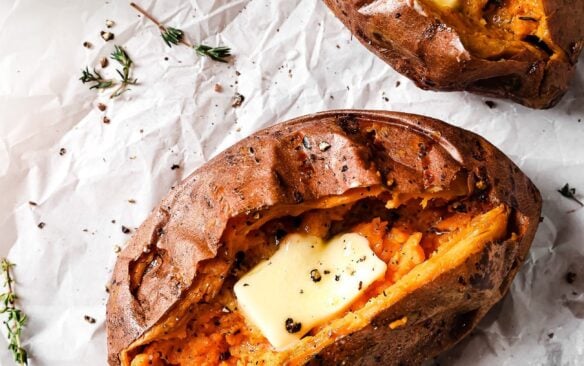 close up of an air fried sweet potato cut in half and filled with butter and herbs