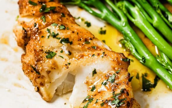 air fried cod on a white plate with a side of broccolini