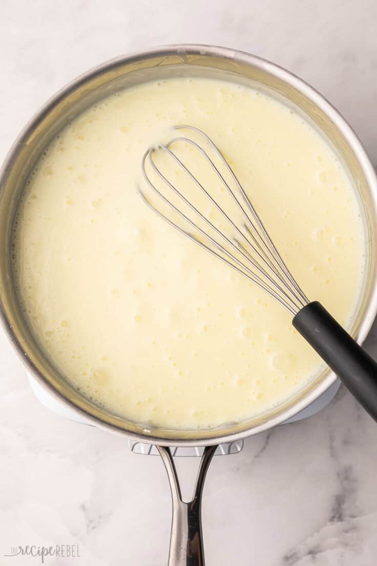 cooked sauce in steel pan with whisk.